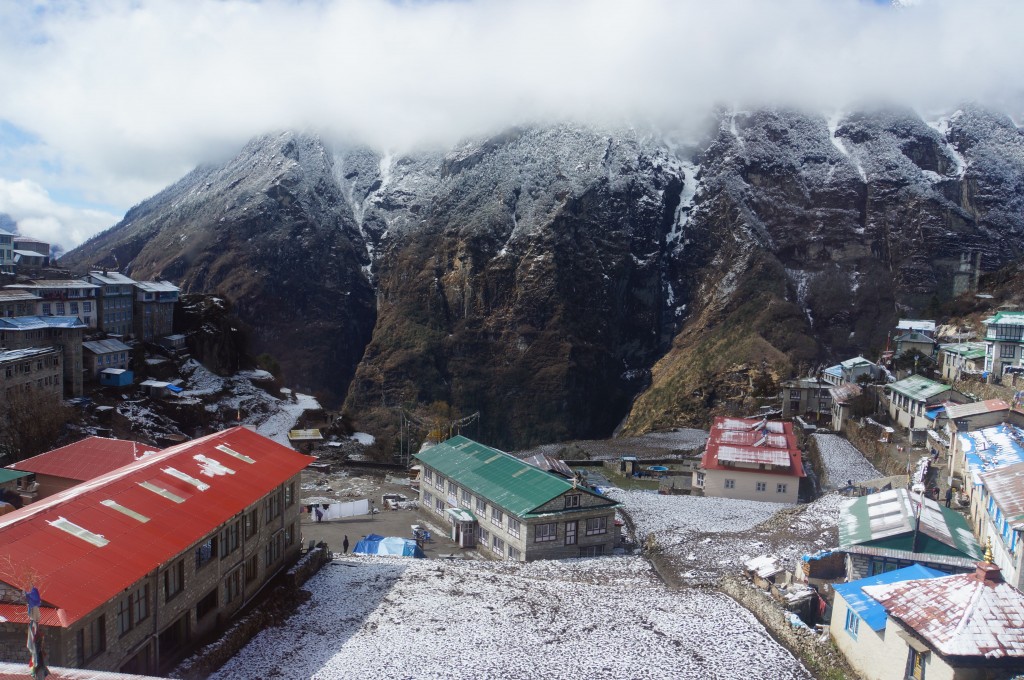 Namche emerges from the clouds in the morning light, new snowfall on the rampart across the valley.