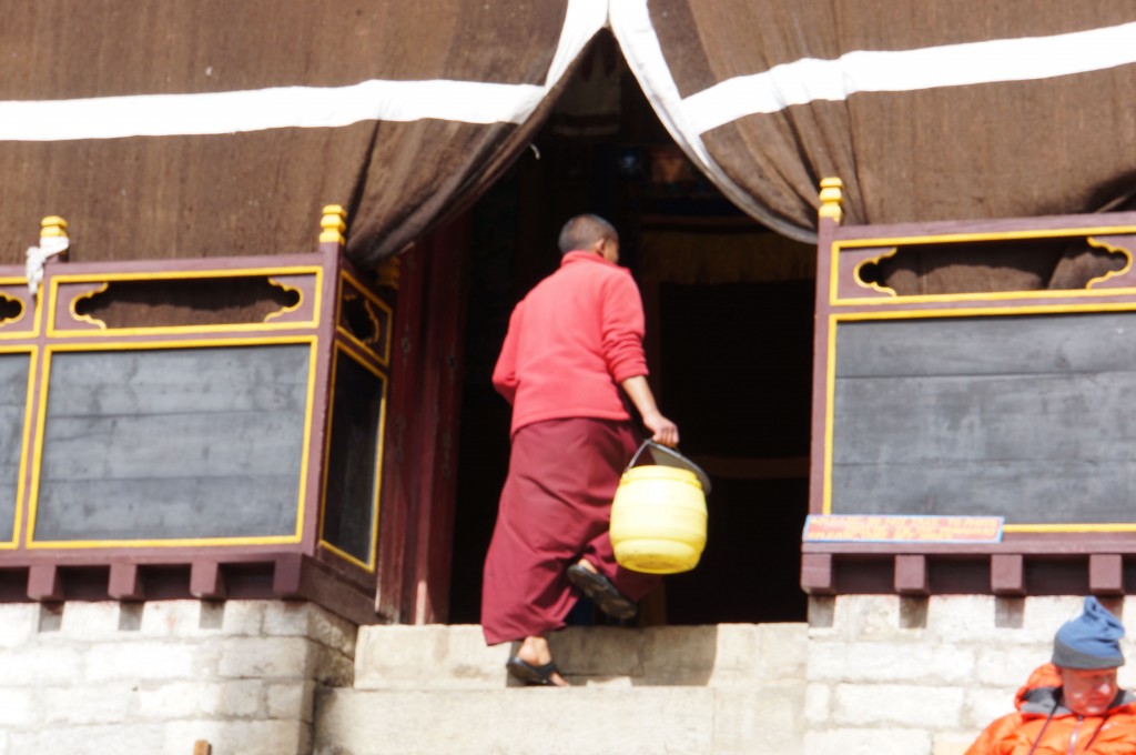 A monk enters the inner sanctum with water to clean the floor before we enter.