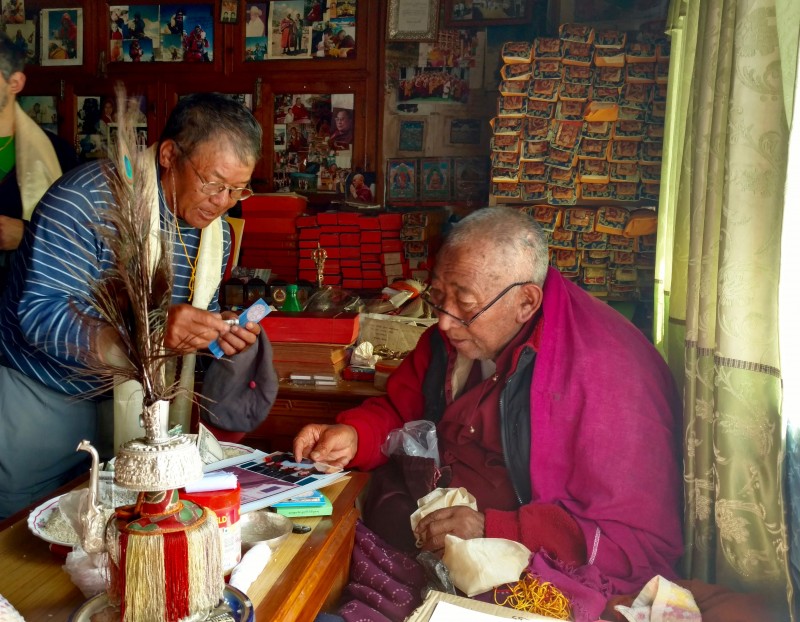Lama Geshi inspects the photo of Gene and nods in approval.