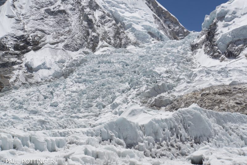 Our nemesis, the formidable gate-keeper to Everest: the Khumbu Icefall. Can you spot the team of climbers making their way down...? Look closely for dark figures at 6:30 from the center of the image, atop a snow plateau.