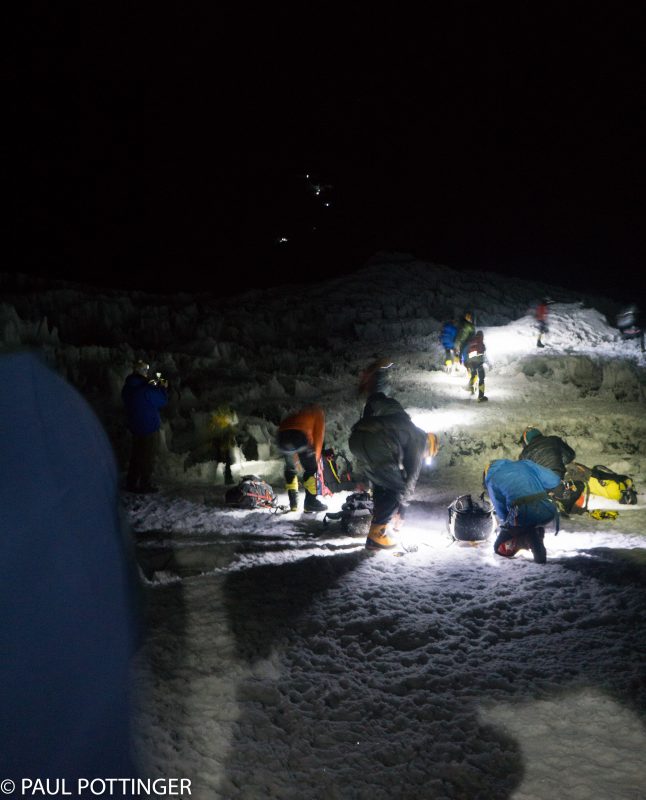 Getting the spikes on at Crampon Point. You can see the headlamps of a handful of climbers on the route above us. Looks busy today, because so many IMG climbers are headed up at once!