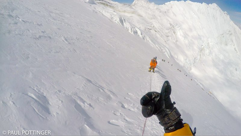 Giving a thumbs up to Nima Dorje soon after the dogleg leading to the Yellow Band. Our tents at Camp 3 barely visible near the bottom of the column of climbers. (GoPro Screenshot)