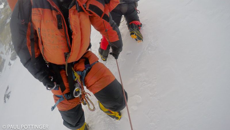 Another Sherpa climber descending the route. Many experienced Sherpa mountaineers are veterans of prior expeditions, which they wear with pride written on their down suits, as this man does. Four prior Everest summits are logged on his suit. (GoPro Screenshot)